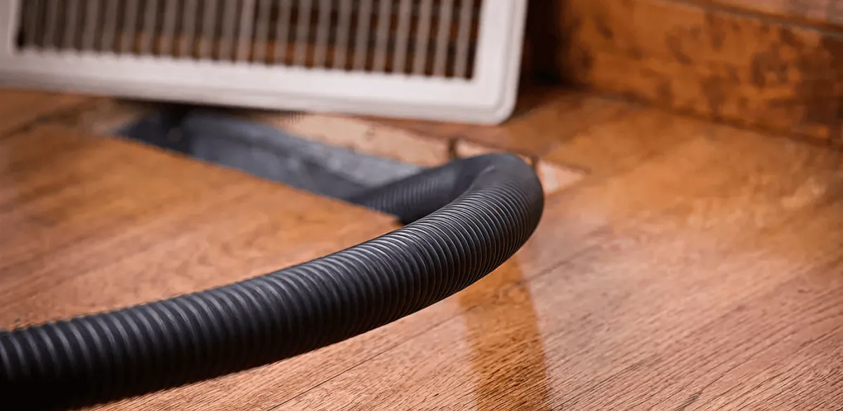 Air duct cleaning hose inserted into a floor vent for ductwork cleaning in Anchorage, AK